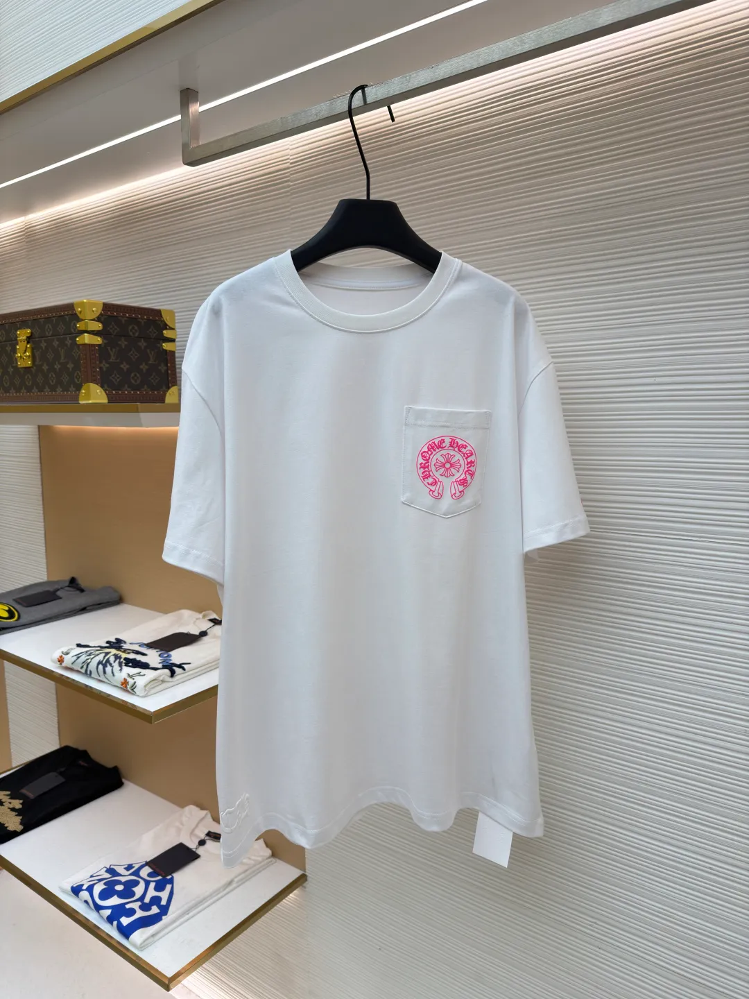 Chrome Hearts horseshoe pink T-shirt ●Item number: 1682507-X85 ●Fabric: cotton fabric ●Technology: hand-printed with ink ●Color: white ●Type: loose fit ●Weight: about 285 grams ●Size: S-M-L ●Description: This Chrome Hearts pocket printed short-sleeves are made of high-count double yarn cotton, with a weight of 320g. The fabric has been pre-washed to achieve a soft and skin-friendly touch. At the same time, it avoids shrinkage and fading problems from the root, and maintains a crisp shape after long-term wear. The body adopts seamless cylinder weaving technology, and there are no seams on the sides, so there is no sense of restraint when worn. The shoulders are classic dropped shoulders, and the loose body shape is suitable for all kinds of body shapes. The rose-red totem print on the left breast pocket is made of imported environmentally friendly slurry and produced through a high-precision screen printing process. The printing has clear layers and saturated colors, and it is not easy to crack or fall off after repeated washing. The neckline adopts a double-needle reinforced hemming design and is paired with a customized threaded collar, which is durable and not easily deformed. The overall wiring follows luxury craftsmanship standards, and the stitching is even and fine. Every detail demonstrates ingenuity. Customized hardware and accessories are complete with three logos, restoring the classic texture of the brand. The overall wiring is straight and delicate, the fabric is comfortable and soft, and the color is consistent without color difference. It can be matched with the same style to create a fashionable look and control various occasions. Customized accessories, complete with three standards, same style for men and women!